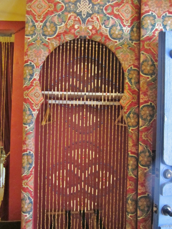 Rich textiles and beaded curtain on doors.